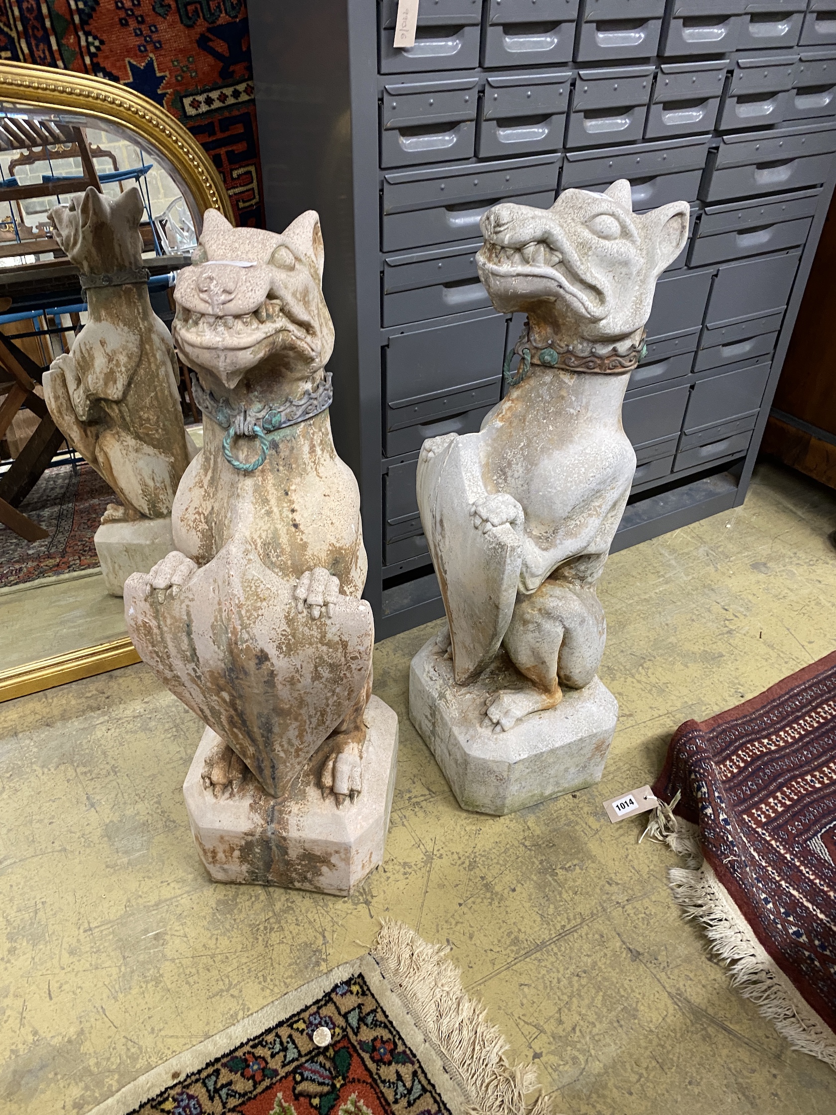 A pair of reconstituted stone dog and shield garden ornaments with cast metal collars, height 81cm